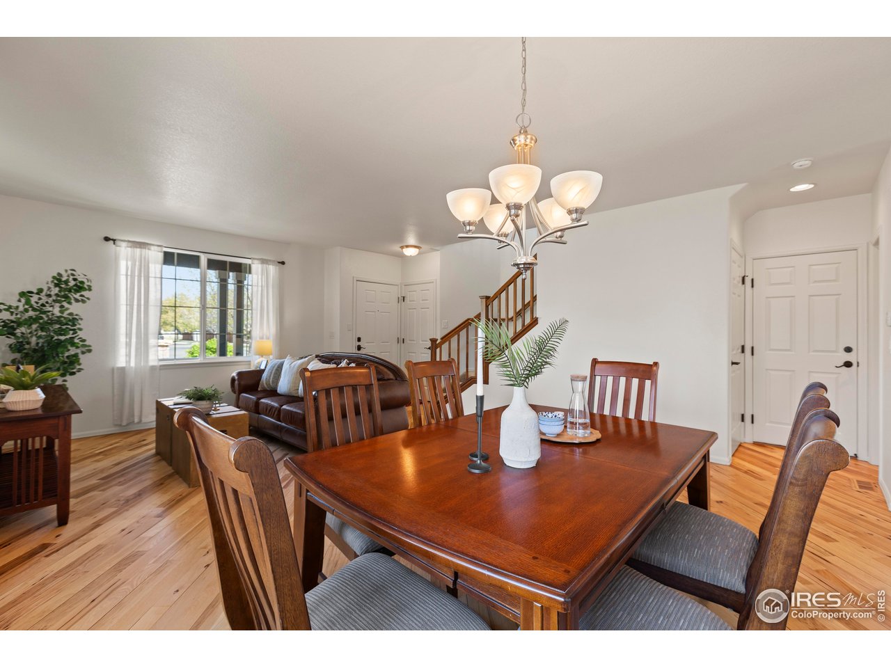 6117 Gold Dust Road Timnath, CO 80547 - Photo 8 of 43 a view of a dining room with furniture wooden floor and chandelier