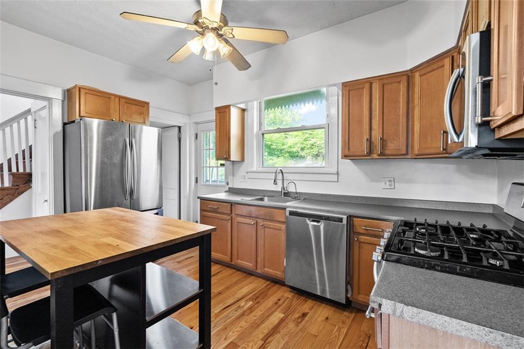 3565 Gerber Avenue Pittsburgh, PA 15212 - Photo 11 of 28 a kitchen with stainless steel appliances a stove a sink dishwasher and wooden cabinets with wooden floor