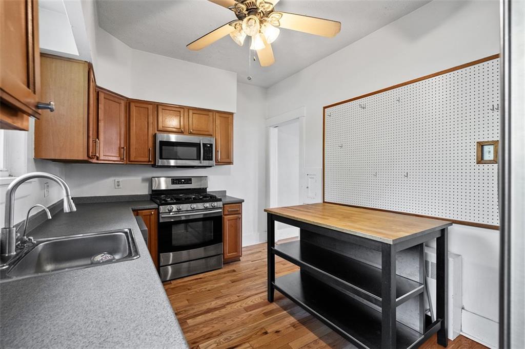 3565 Gerber Avenue Pittsburgh, PA 15212 - Photo 12 of 28 a kitchen with stainless steel appliances granite countertop a stove a sink and a microwave