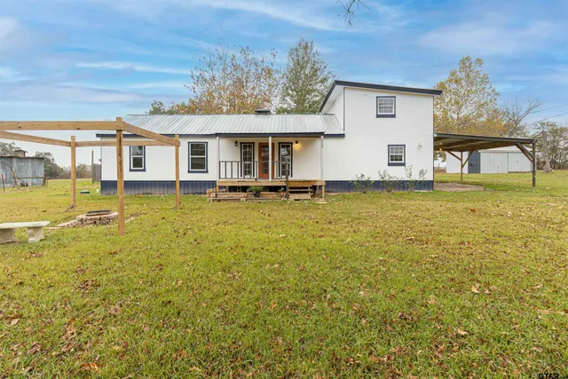 a view of a house with a big yard and potted plants