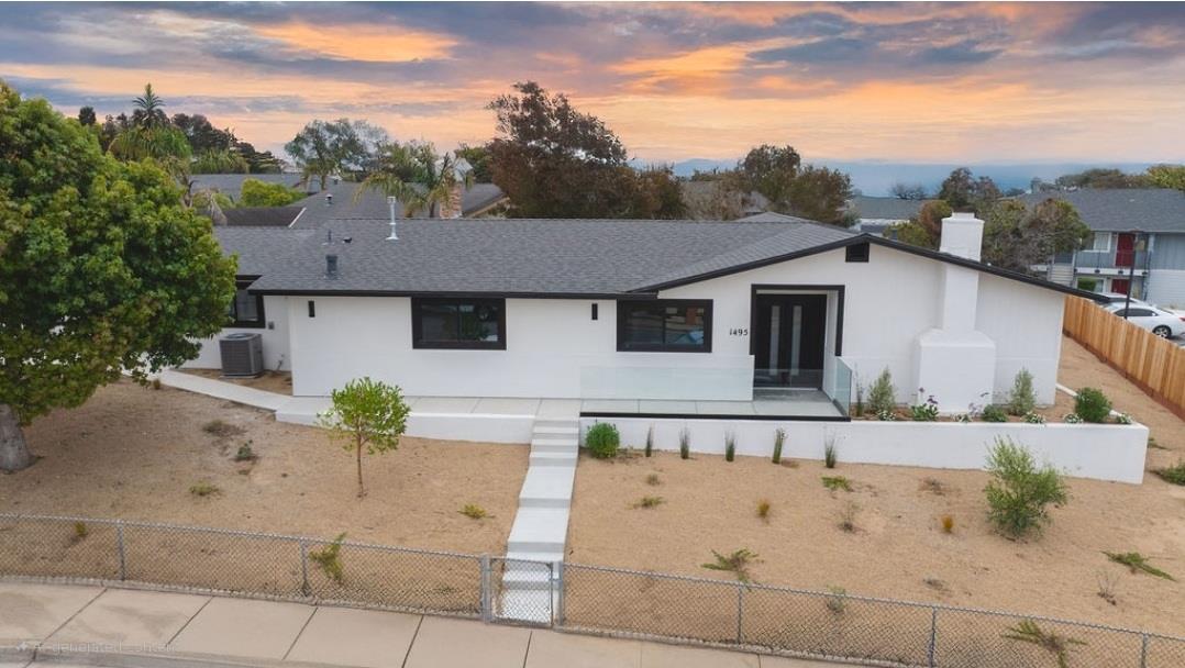 a white house with a large pool of the back yard