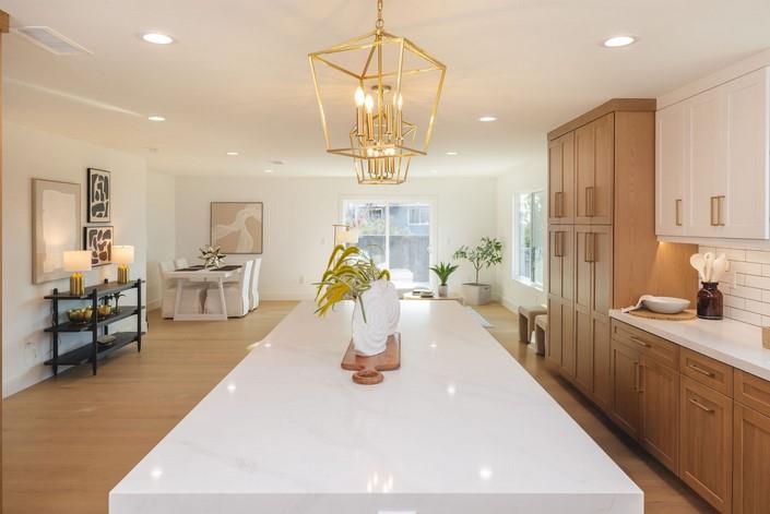 1495 Ancon Street Seaside, CA 93955 - Photo 10 of 35 a room with stainless steel appliances a dining table wooden floor chairs and a chandelier