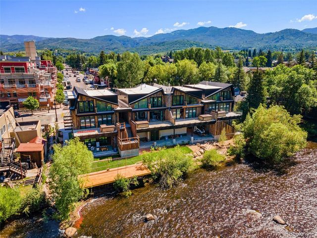 an aerial view of a house with yard swimming pool and mountains