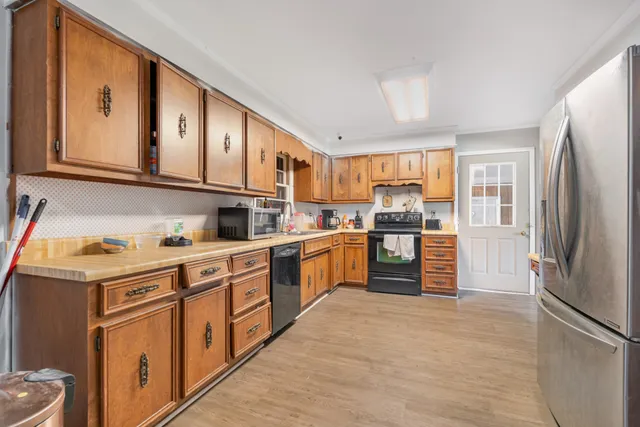 a kitchen with stainless steel appliances granite countertop a refrigerator and a stove top oven