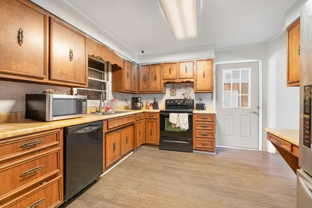 a kitchen with stainless steel appliances granite countertop a refrigerator and a stove top oven