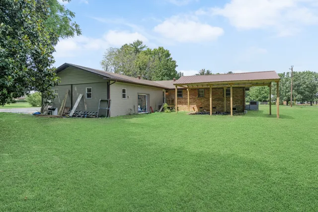 a view of a backyard with table and chairs with a tree