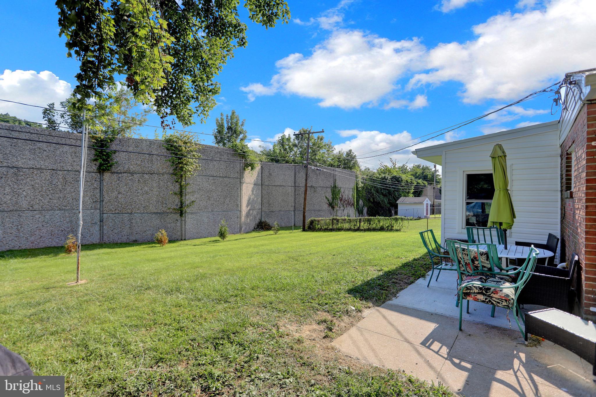 2608 Burridge Road Parkville, MD 21234 - Photo 12 of 15 a view of a backyard with table and chairs potted plants and a large tree