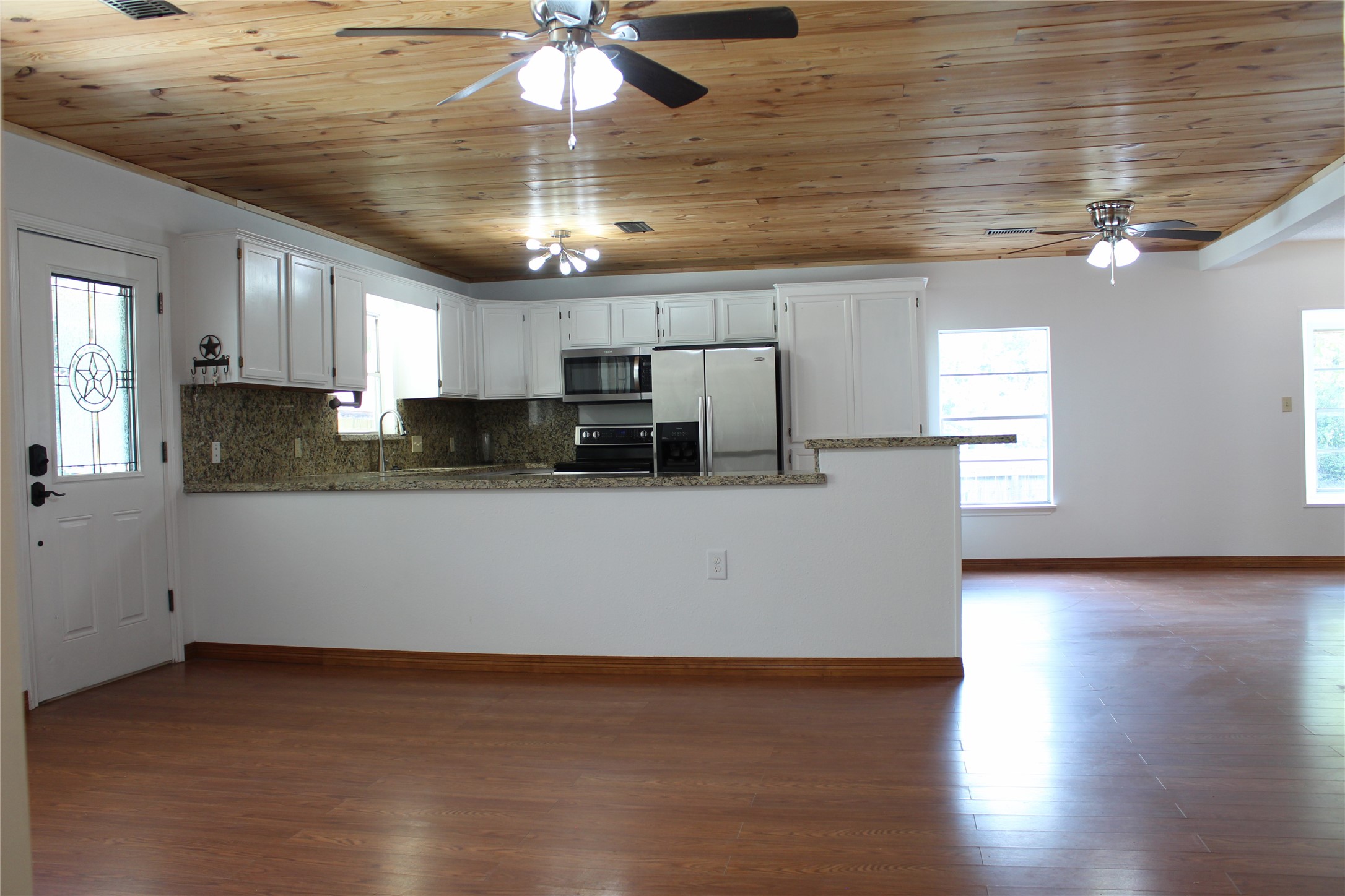 14040 FM 1484 Road Conroe, TX 77303 - Photo 16 of 47 a kitchen with stainless steel appliances granite countertop a refrigerator a sink dishwasher a stove and white cabinets with wooden floor