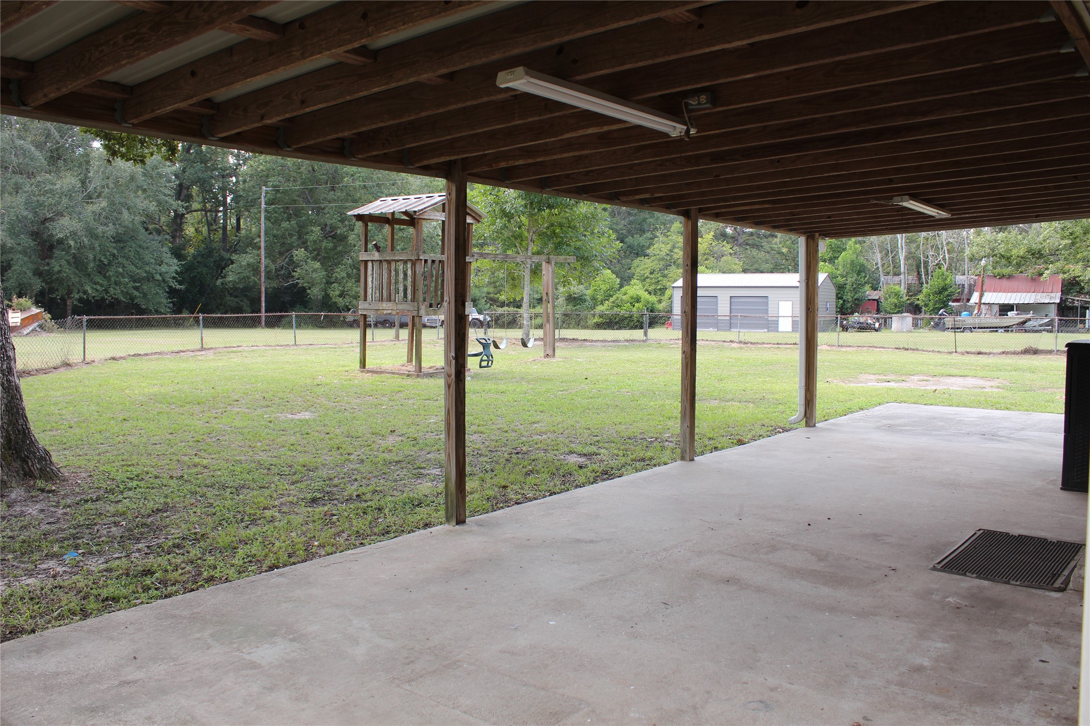 14040 FM 1484 Road Conroe, TX 77303 - Photo 27 of 47 a view of a backyard with table and chairs under an umbrella