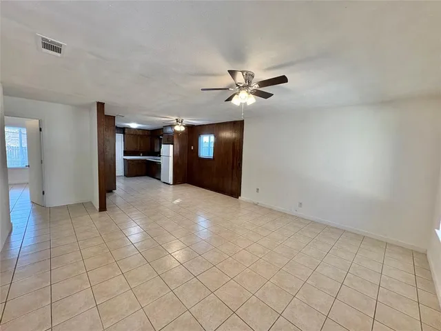 a view of a livingroom with a chandelier fan and windows