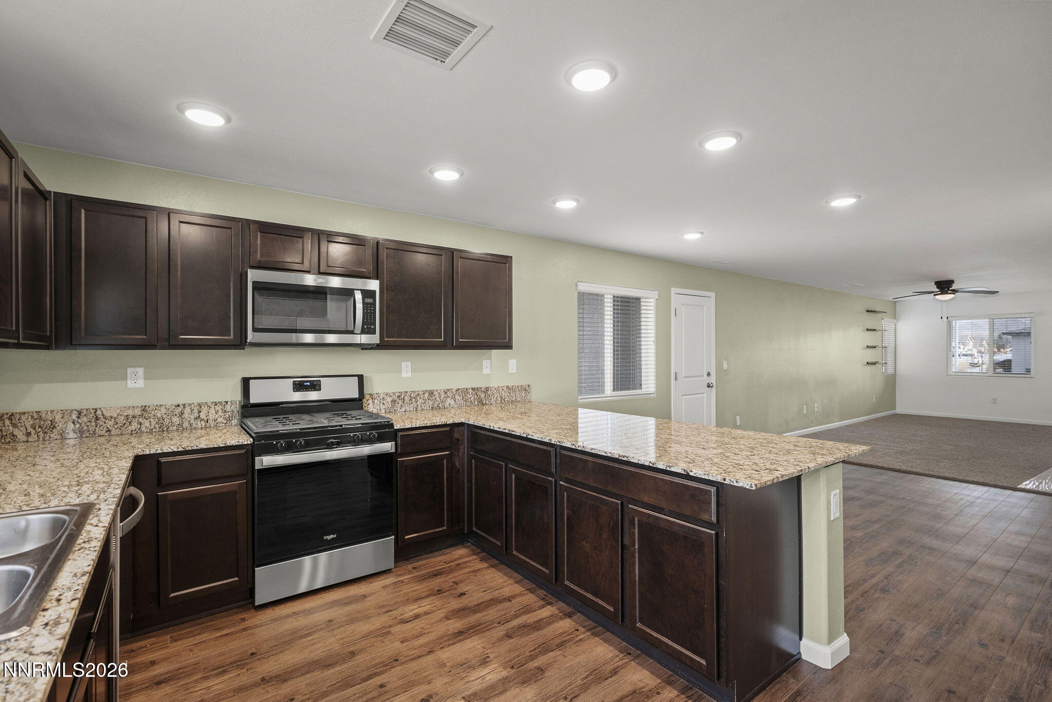 7709 Sandy Valley Drive Reno, NV 89506 - Photo 16 of 35 a kitchen with stainless steel appliances granite countertop a sink stove and microwave