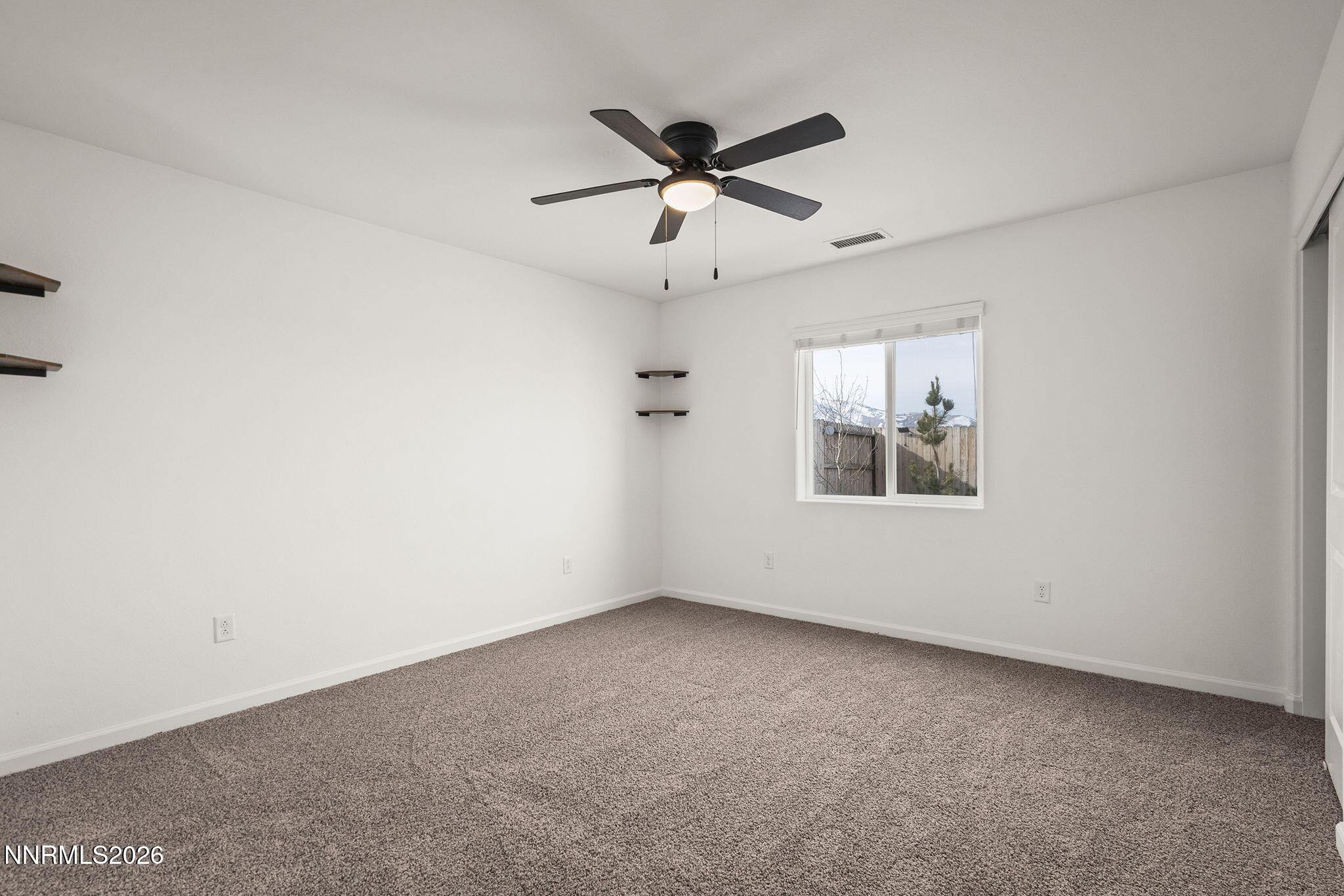 7709 Sandy Valley Drive Reno, NV 89506 - Photo 19 of 35 an empty room with a window and a fan