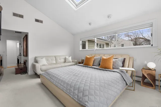 a bedroom with a large bed and paintings on the wall