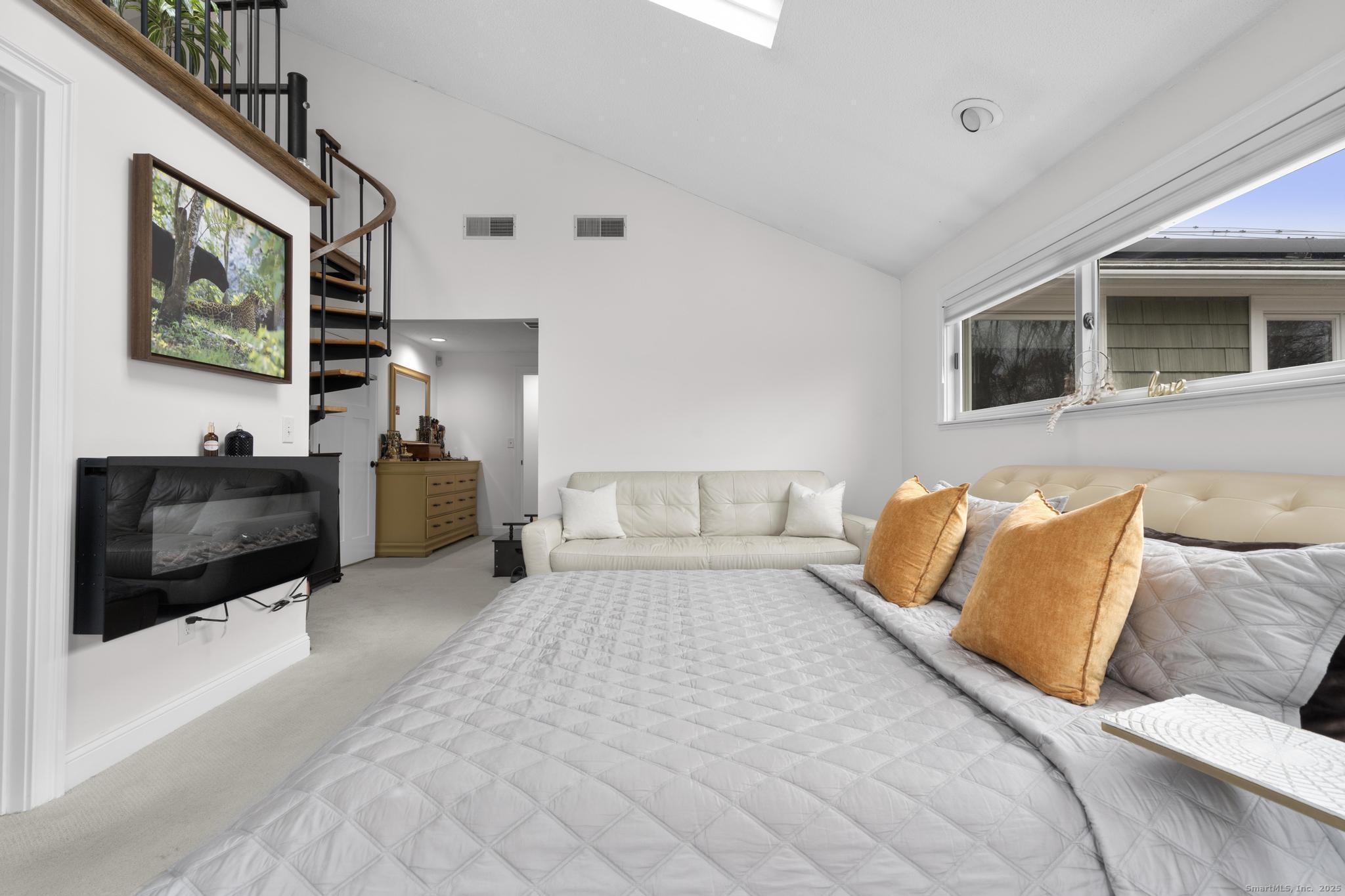 57 Gray Rock Road Trumbull, CT 06611 - Photo 13 of 40 a spacious bedroom with a bed a couch and a flat screen tv