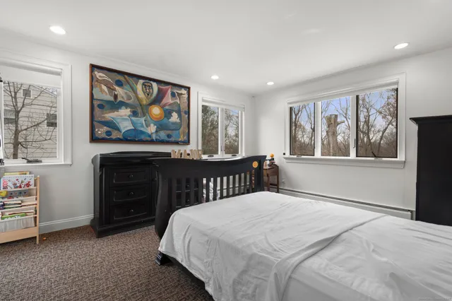 a bedroom with a bed and a painting on the wall