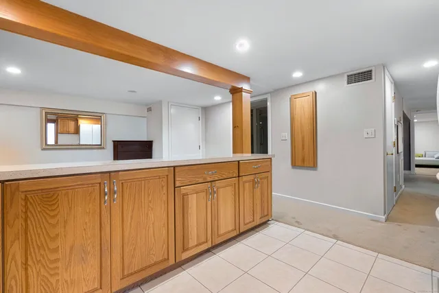a view of a hallway with wooden cabinets