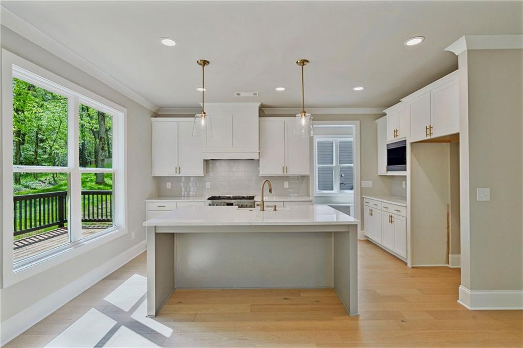 1697 Eastside Parc Street Atlanta, GA 30316 - Photo 16 of 44 a large kitchen with kitchen island a large counter top space a sink stainless steel appliances and cabinets
