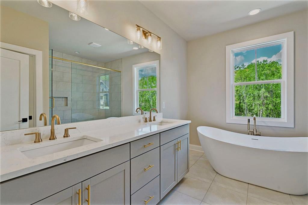 1697 Eastside Parc Street Atlanta, GA 30316 - Photo 26 of 44 a bathroom with a double vanity sink bathtub and next to a window