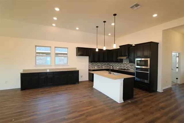 a kitchen with a sink window and cabinets