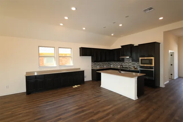 wooden floor in an empty room with a kitchen