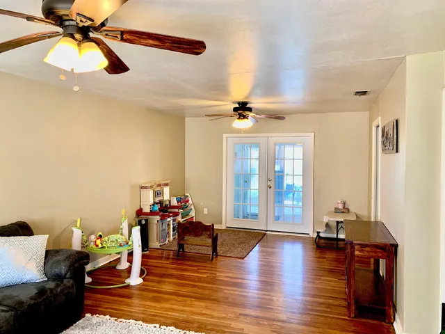 a living room with furniture and wooden floor