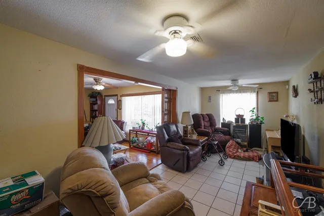 a living room with furniture a flat screen tv and a window
