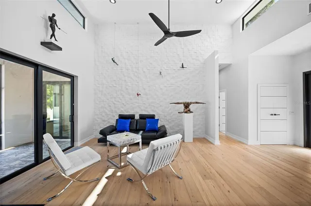 a living room with furniture a clock on wall and a window