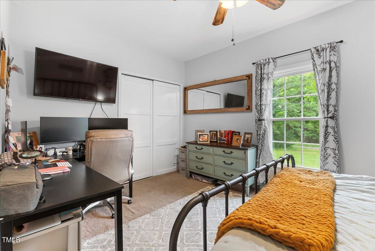 3151 Brogden Road Stem, NC 27581 - Photo 16 of 58 a bedroom with a bed and a flat screen tv