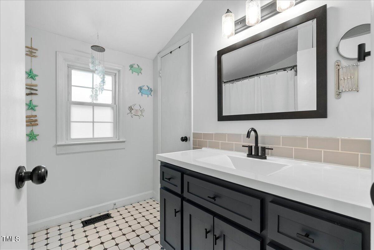 3151 Brogden Road Stem, NC 27581 - Photo 21 of 58 a bathroom with a sink a vanity and a mirror