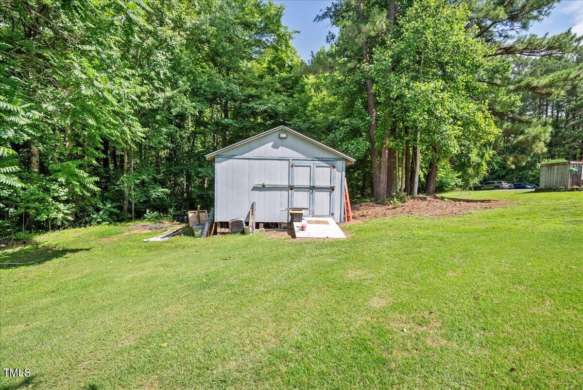 3151 Brogden Road Stem, NC 27581 - Photo 43 of 58 a front view of a house with a yard and trees