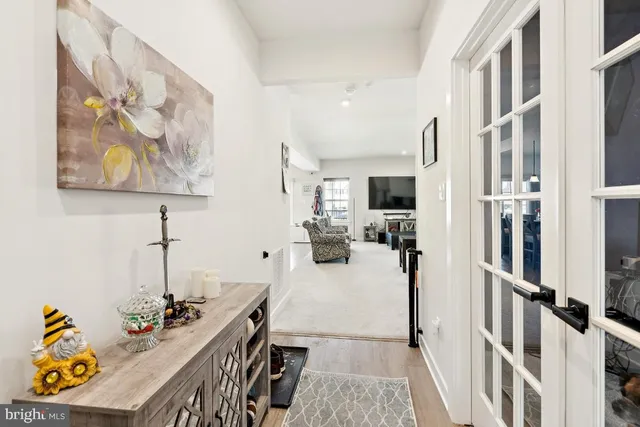 a view of a hallway with dining room and wooden floor