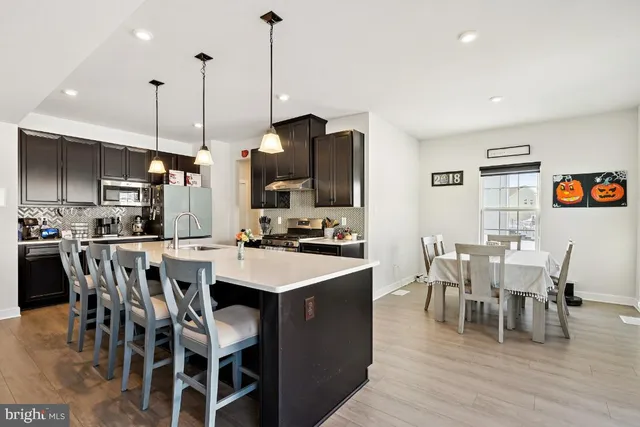a view of a dining room and livingroom with furniture wooden floor a chandelier