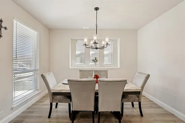 a dining room with furniture a chandelier and wooden floor