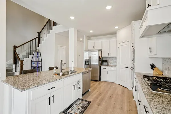 a kitchen with stainless steel appliances kitchen island granite countertop a stove a sink and a refrigerator