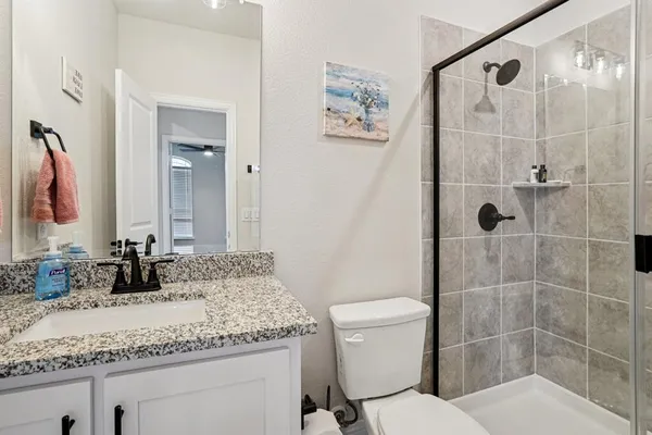 a bathroom with a granite countertop sink toilet and shower