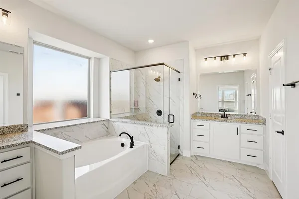 a bathroom with a granite countertop tub sink shower and mirror