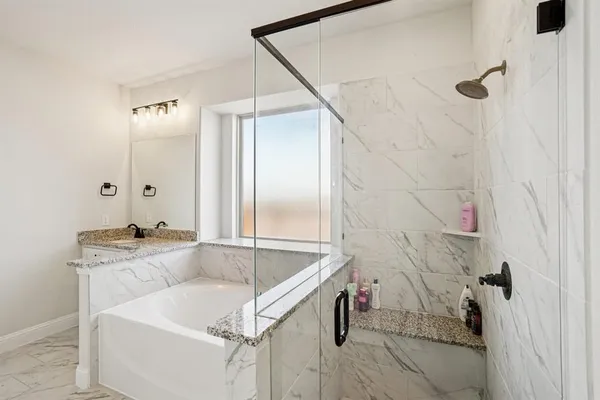 a bathroom with a tub sink and mirror