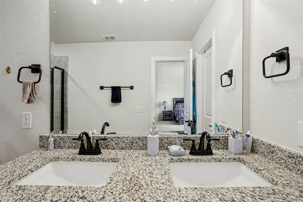a bathroom with a granite countertop sink vanity and mirror
