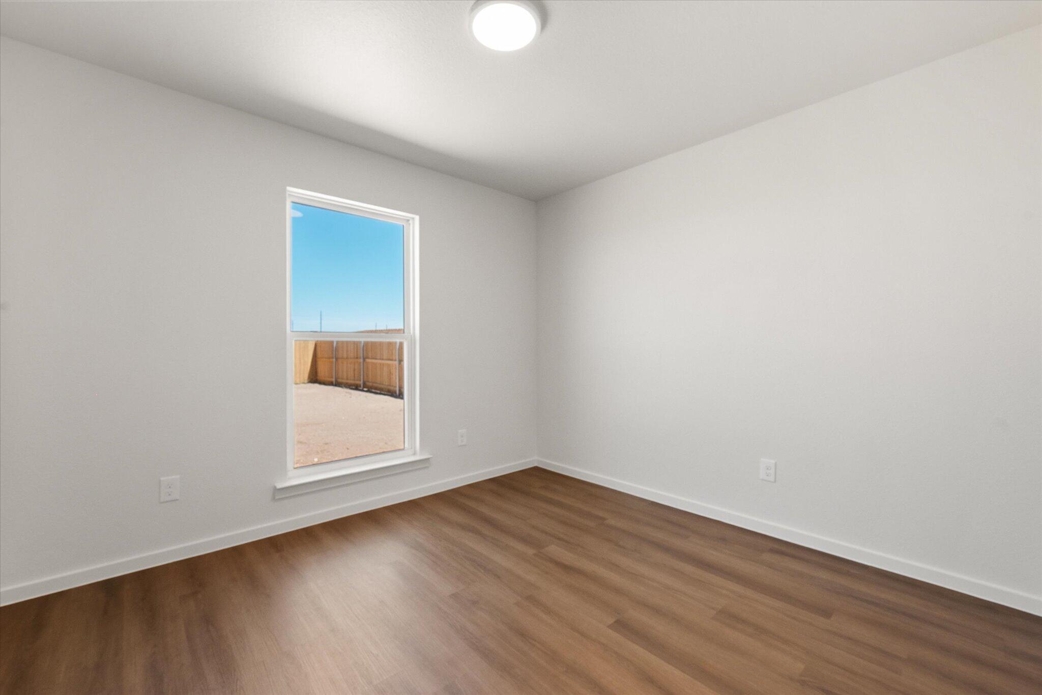 5518 Smith Street Lubbock, TX 79416 - Photo 19 of 22 an empty room with wooden floor and windows
