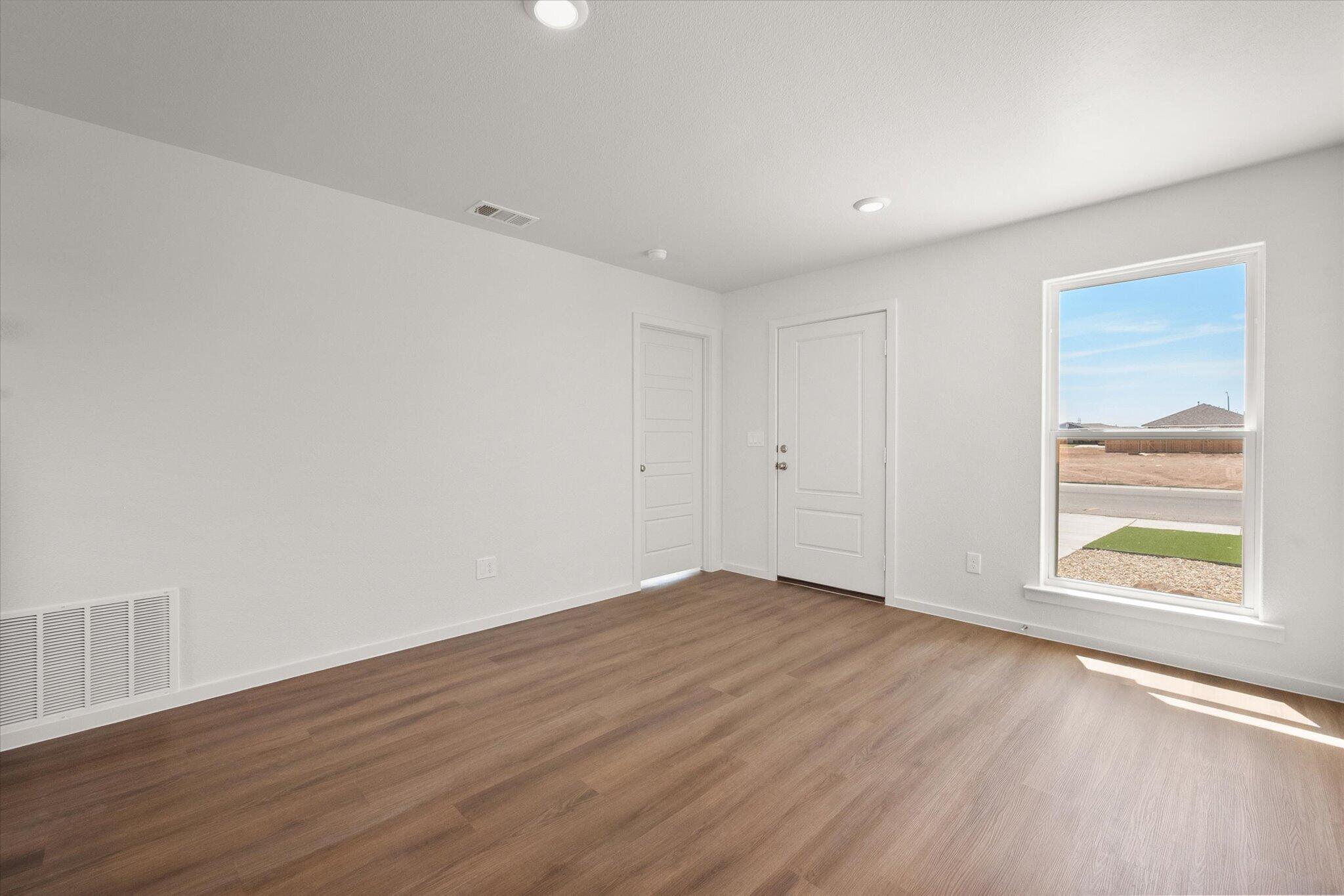 5518 Smith Street Lubbock, TX 79416 - Photo 6 of 22 a view of an empty room with wooden floor and a window