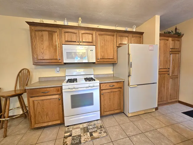 a kitchen with a refrigerator sink and cabinets