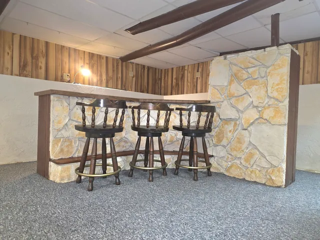 a house with wooden floor outdoor seating and yard in the back