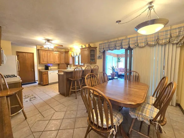 a dining room with furniture a chandelier and kitchen view