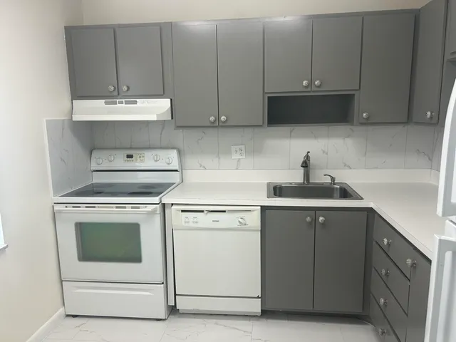 a kitchen with cabinets and white appliances
