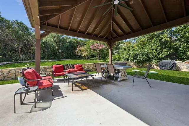 a patio with a table and chairs under an umbrella