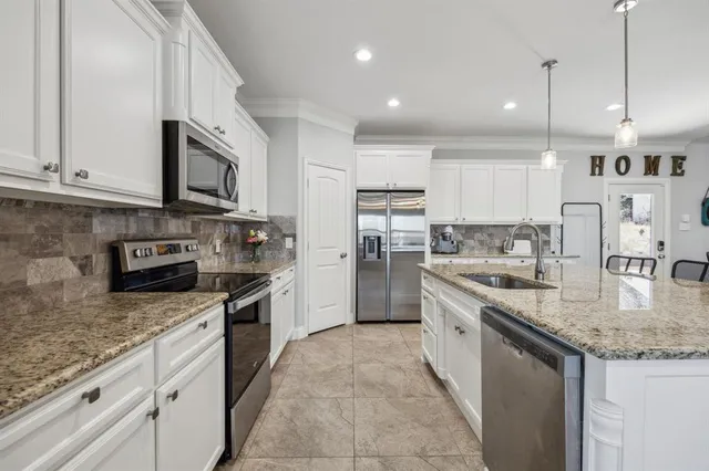 a kitchen with stainless steel appliances granite countertop a sink stove and refrigerator