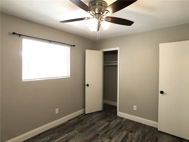 an empty room with a window and a fan