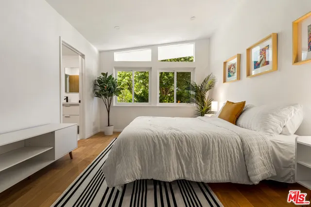 a bed sitting in a bedroom next to a window