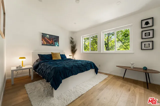 a bedroom with a bed and a lamp on dresser