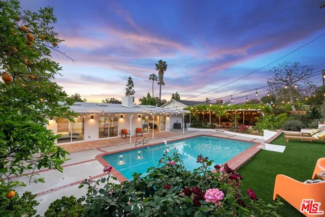 an aerial view of a house with swimming pool garden and lake view